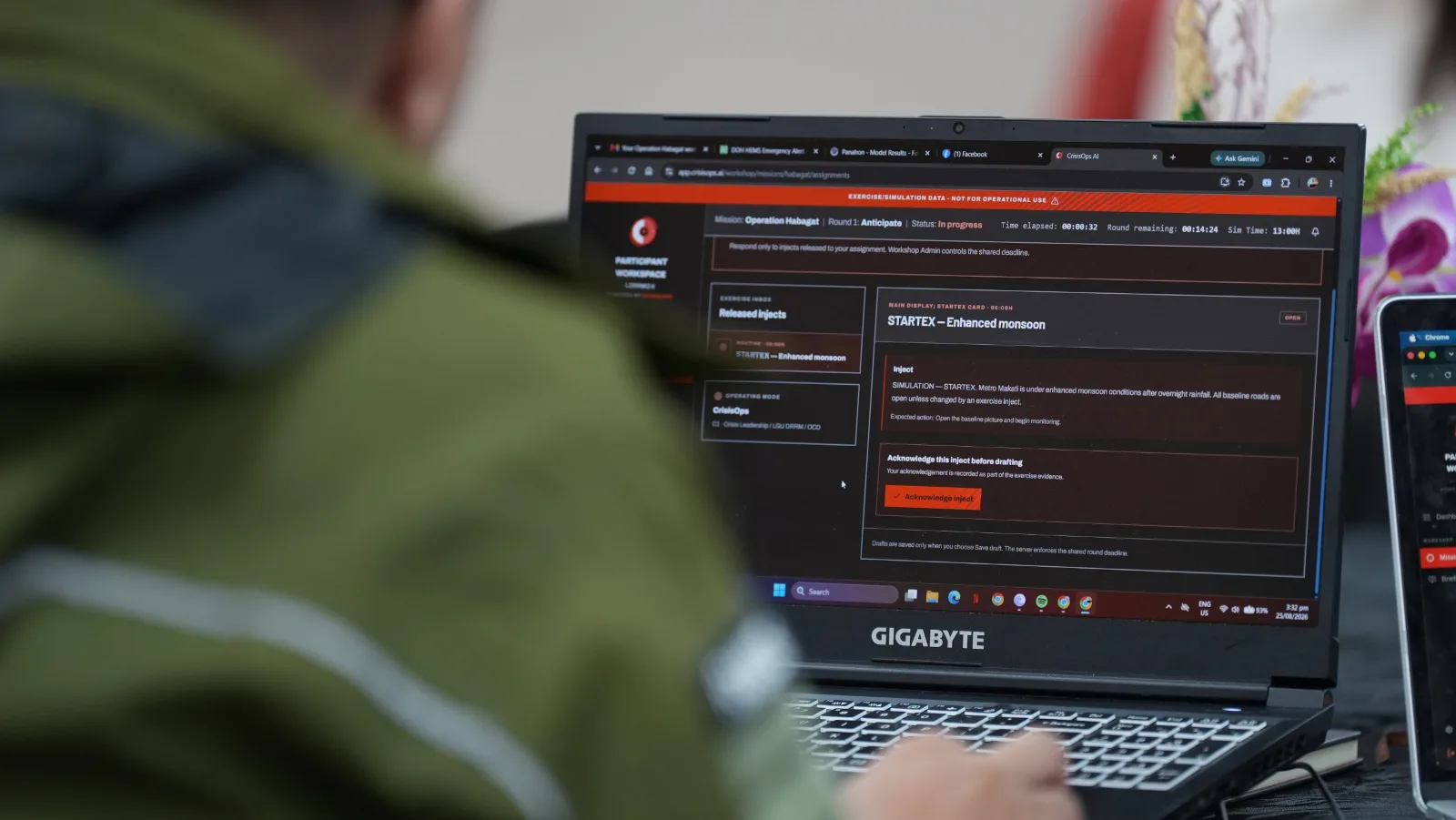 An event participant explores the CrisisOps platform on a computer, viewing operational information and disaster-response data.